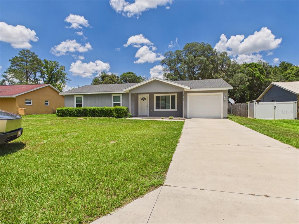 4309 Southwest 143rd Ln Road Ocala, FL 34473 - Photo 2 of 21 a front view of a house with a garden and yard