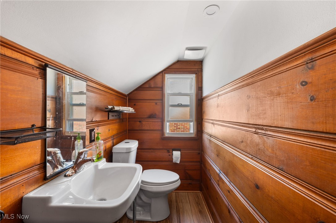 18122 Nottingham Road Cleveland, OH 44119 - Photo 19 of 29 Half bathroom featuring vaulted ceiling, dark wood-style flooring, and wooden walls