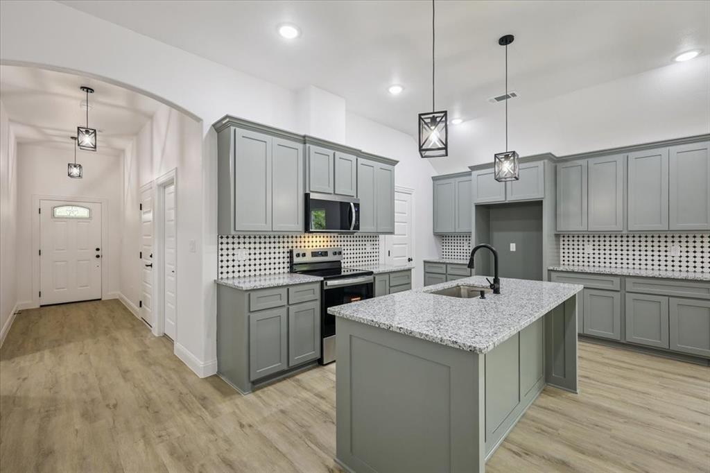 a kitchen with a sink a stove a refrigerator and a microwave