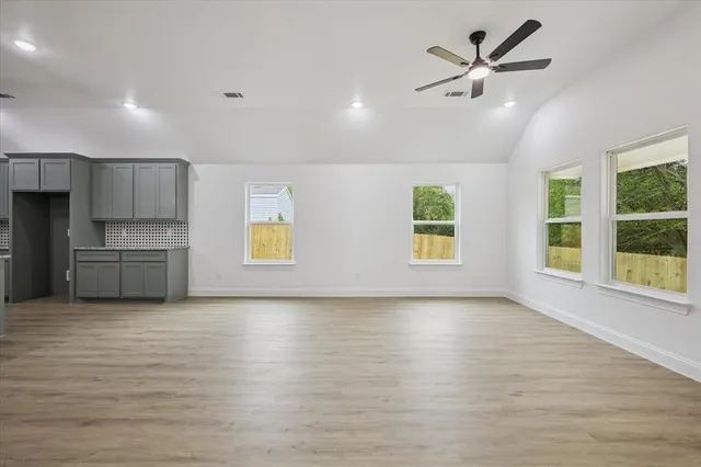 a view of kitchen with stainless steel appliances granite countertop a stove a sink dishwasher and a refrigerator with wooden floor