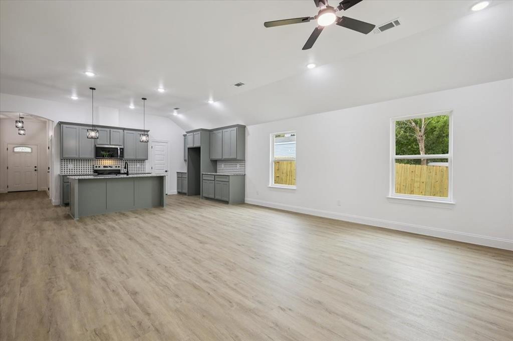 111 North Oak Street Ector, TX 75439 - Photo 13 of 34 a view of kitchen with stainless steel appliances kitchen island hardwood floor and a window