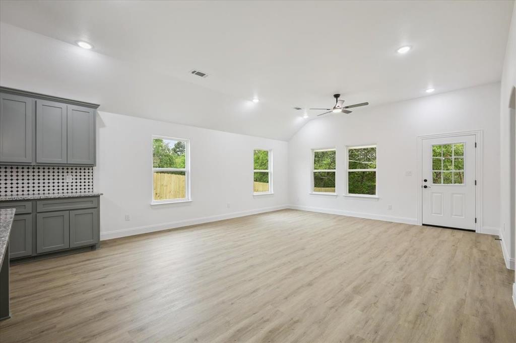 111 North Oak Street Ector, TX 75439 - Photo 14 of 34 an empty room with wooden floor and windows