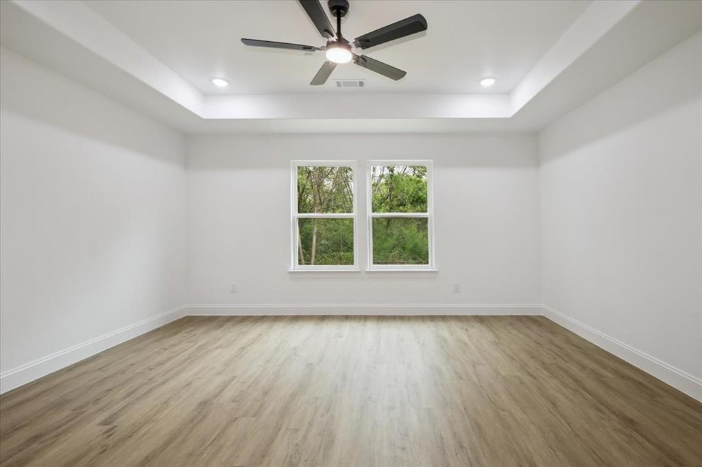 111 North Oak Street Ector, TX 75439 - Photo 25 of 34 wooden floor in an empty room with a window