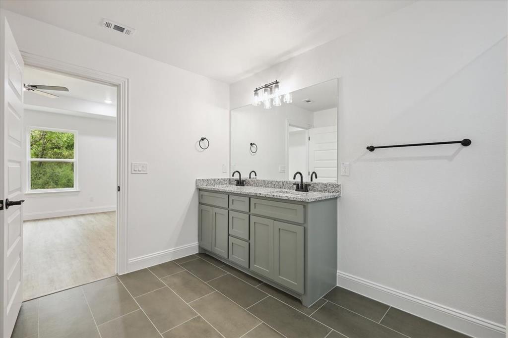 111 North Oak Street Ector, TX 75439 - Photo 28 of 34 a bathroom with a sink vanity and a mirror