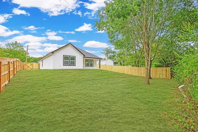 a house with green field in front of it