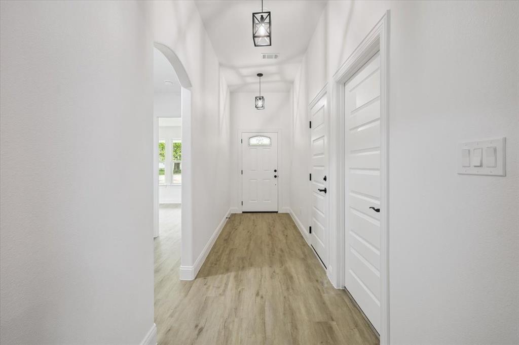 111 North Oak Street Ector, TX 75439 - Photo 4 of 34 a view of a hallway with wooden floor and staircase
