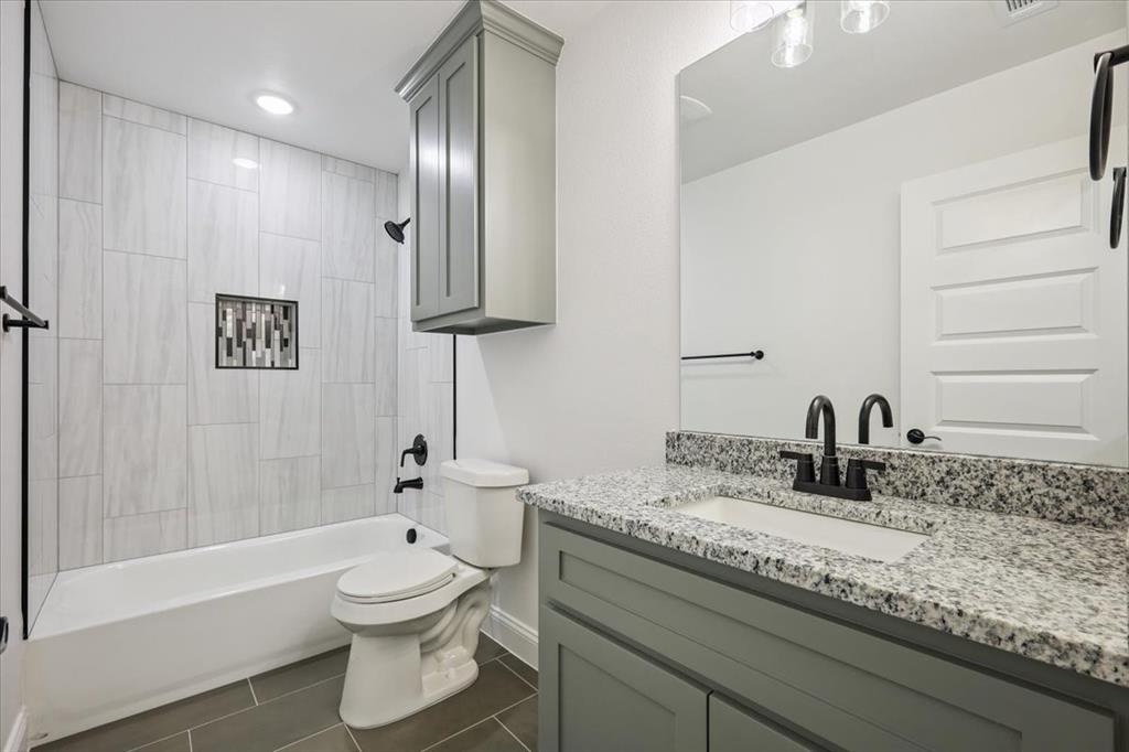 111 North Oak Street Ector, TX 75439 - Photo 8 of 34 a bathroom with a granite countertop sink a toilet and bathtub