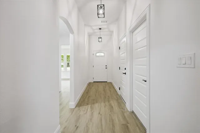a view of a hallway with wooden floor and staircase