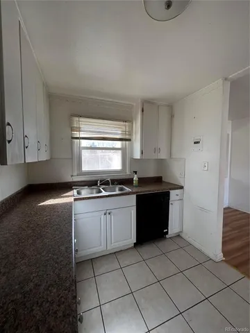a kitchen with granite countertop a sink a stove and cabinets