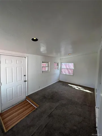a view of room with hardwood floor and hallway
