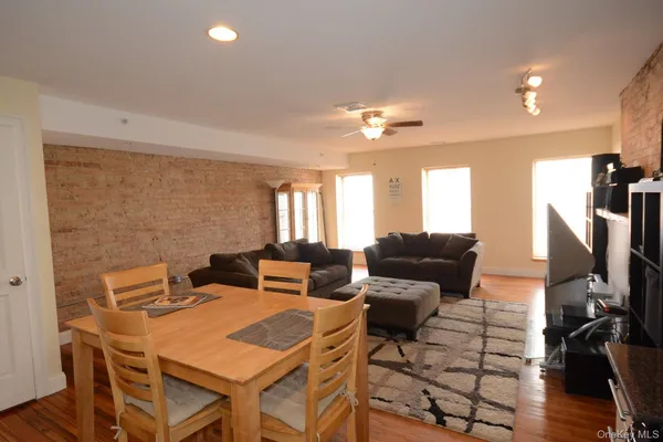 a view of a dining room with furniture a rug and wooden floor