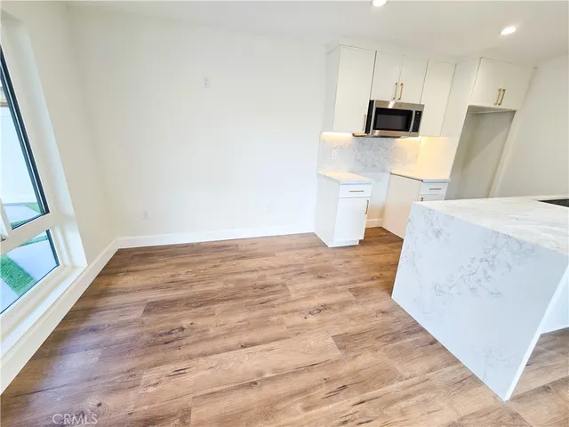 a view of a kitchen with wooden floor and a sink