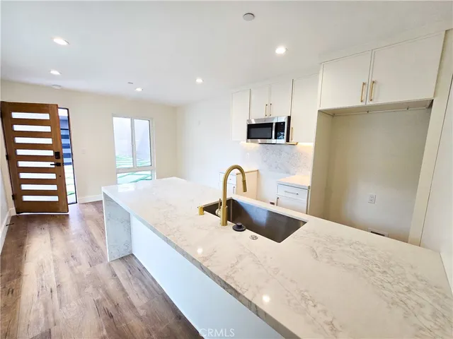 a kitchen with stainless steel appliances a microwave a stove a sink a refrigerator and cabinets