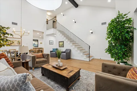 a living room with furniture wooden floor and a large window