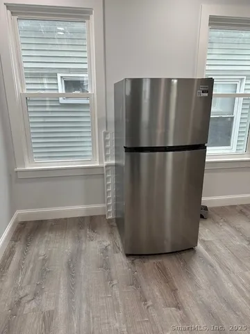 a view of a refrigerator in kitchen and a window
