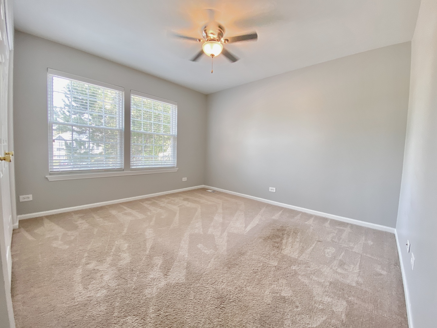 2443 Baldwin Court Aurora, IL 60503 - Photo 30 of 51 an empty room with windows and a ceiling fan