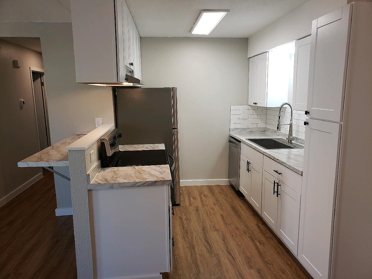802 Ranch Road, Unit A Georgetown, TX 78628 - Photo 4 of 11 Modern kitchen with stylish white cabinetry and a convenient breakfast bar for casual dining.