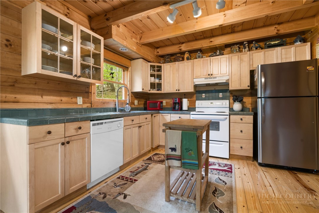 259 Greenbriar Road Beech Mountain, NC 28604 - Photo 7 of 41 a kitchen with cabinets appliances a sink and a dining table