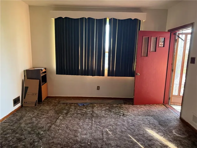 an empty room with wooden floor and a window