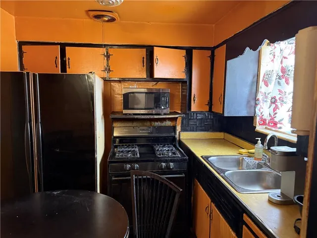 a kitchen that has a sink a stove and a refrigerator