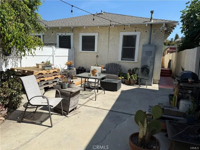 a view of a patio with couches table and chairs and potted plants