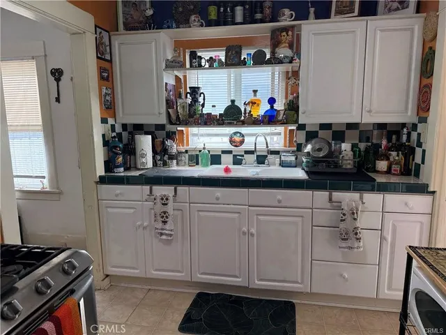 a kitchen with white cabinets and appliances