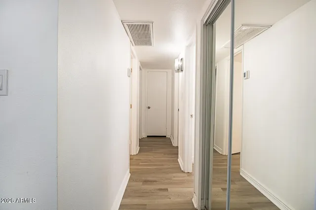 a view of a hallway with wooden floor