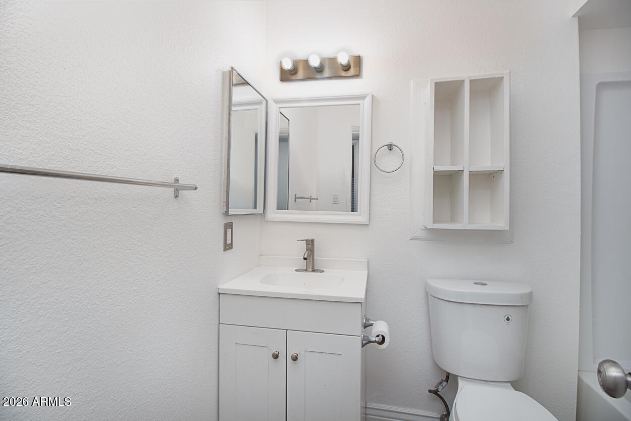 555 North May, Unit 3 Mesa, AZ 85201 - Photo 14 of 26 a bathroom with a toilet sink and mirror