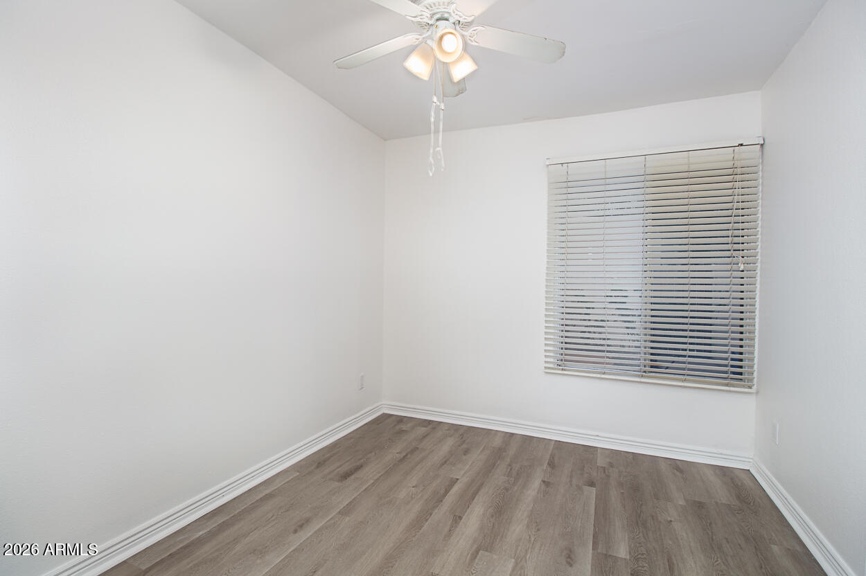 555 North May, Unit 3 Mesa, AZ 85201 - Photo 16 of 26 a view of an empty room with wooden floor and a window