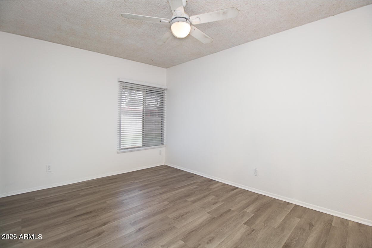 555 North May, Unit 3 Mesa, AZ 85201 - Photo 20 of 26 an empty room with wooden floor and windows