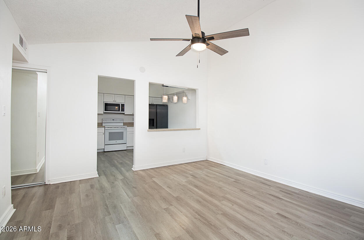 555 North May, Unit 3 Mesa, AZ 85201 - Photo 5 of 26 a view of a kitchen with wooden floor electronic appliances and a ceiling fan
