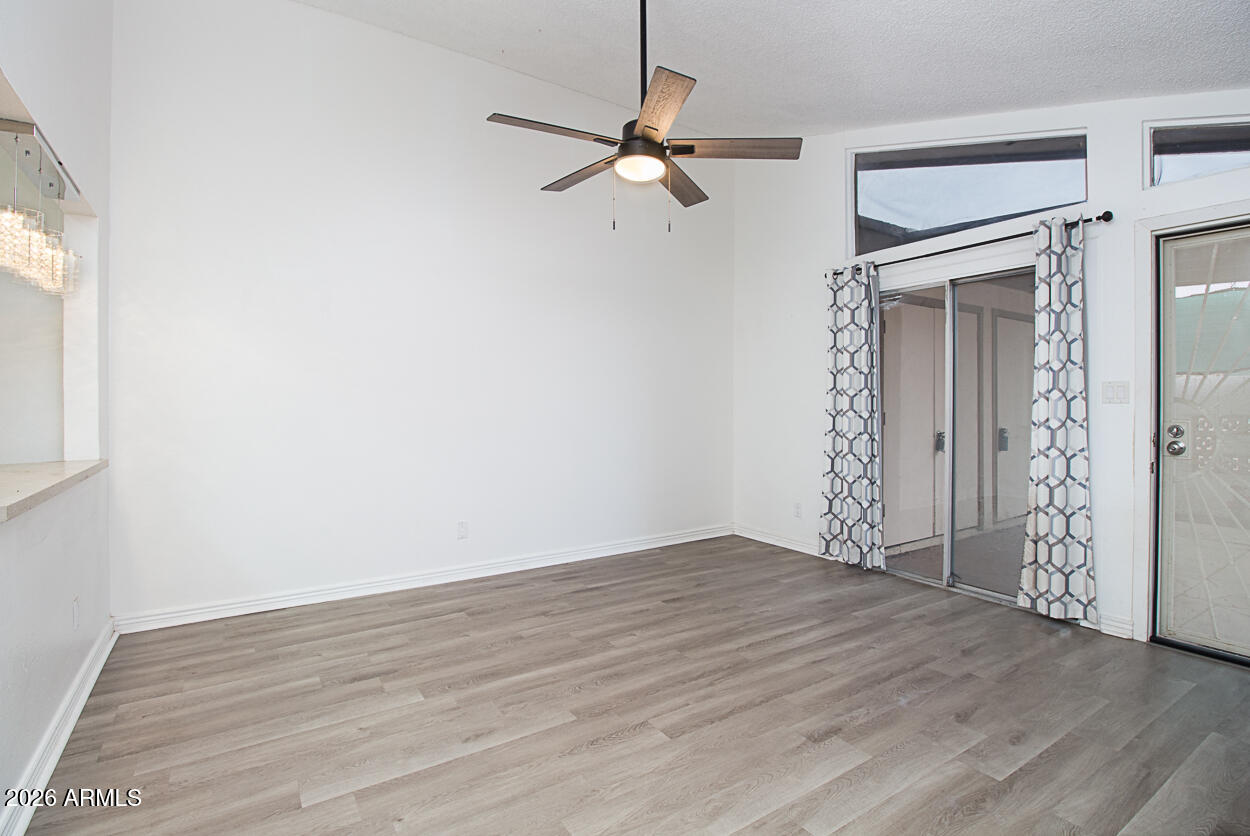 555 North May, Unit 3 Mesa, AZ 85201 - Photo 8 of 26 a view of an empty room with wooden floor and a ceiling fan