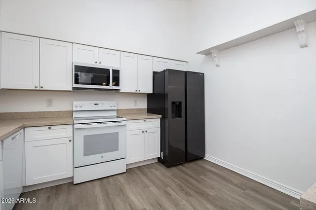 a kitchen with stainless steel appliances white cabinets a sink and a microwave