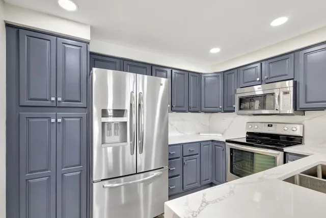 a kitchen with granite countertop a sink and cabinets