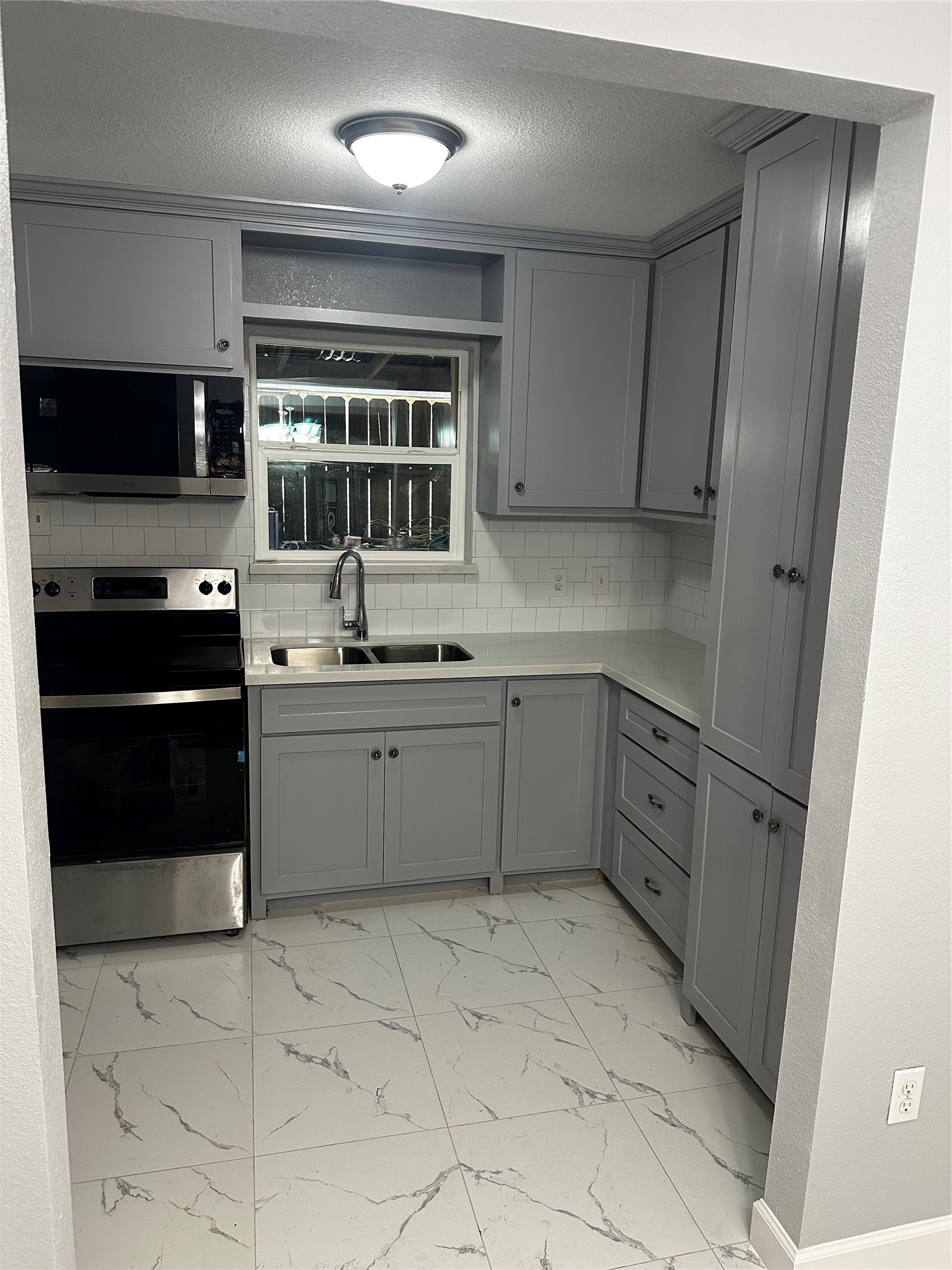 a kitchen with a stove sink and cabinets