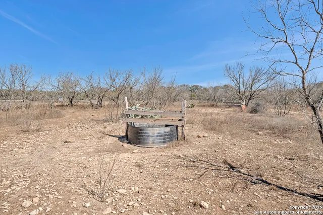 a view of a dry yard with wooden fence