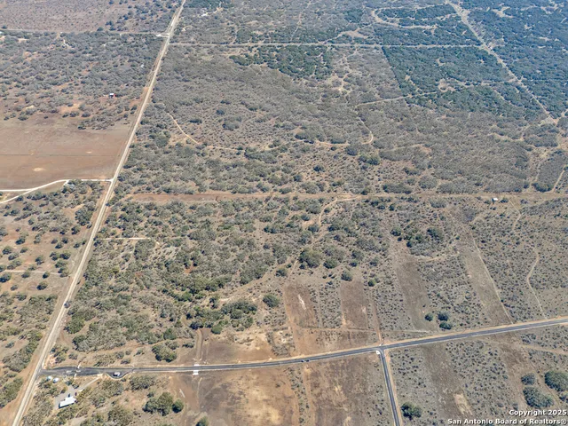 a view of a dry yard with wooden fence