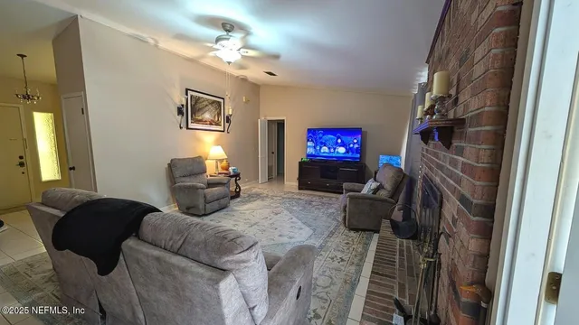 a living room with furniture a fireplace and a chandelier