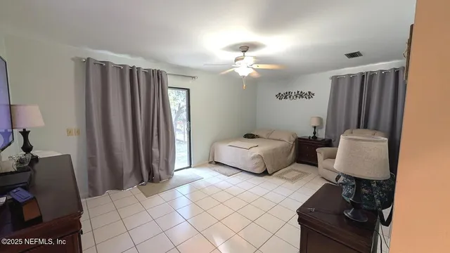 a spacious bedroom with a bed and a flat screen tv