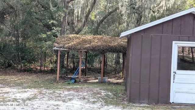 a view of a chair and table in backyard of the house