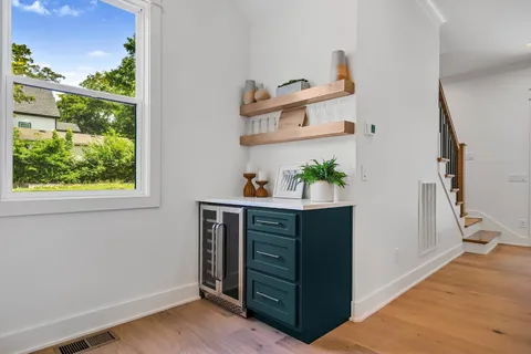 a view of a hallway to room with wooden floor and a potted plant