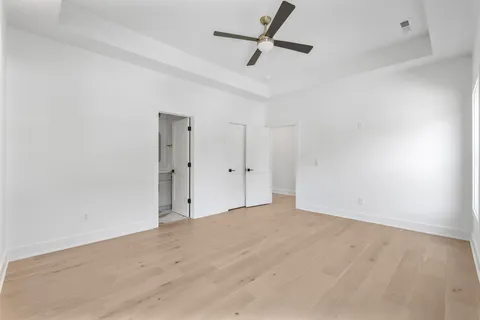 an empty room with an entryway and fan