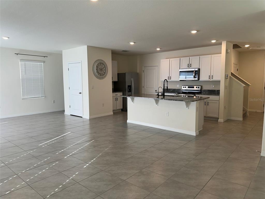 33762 Jasmine Star Loop Wesley Chapel, FL 33543 - Photo 5 of 27 a kitchen with stainless steel appliances granite countertop a sink stove and cabinets