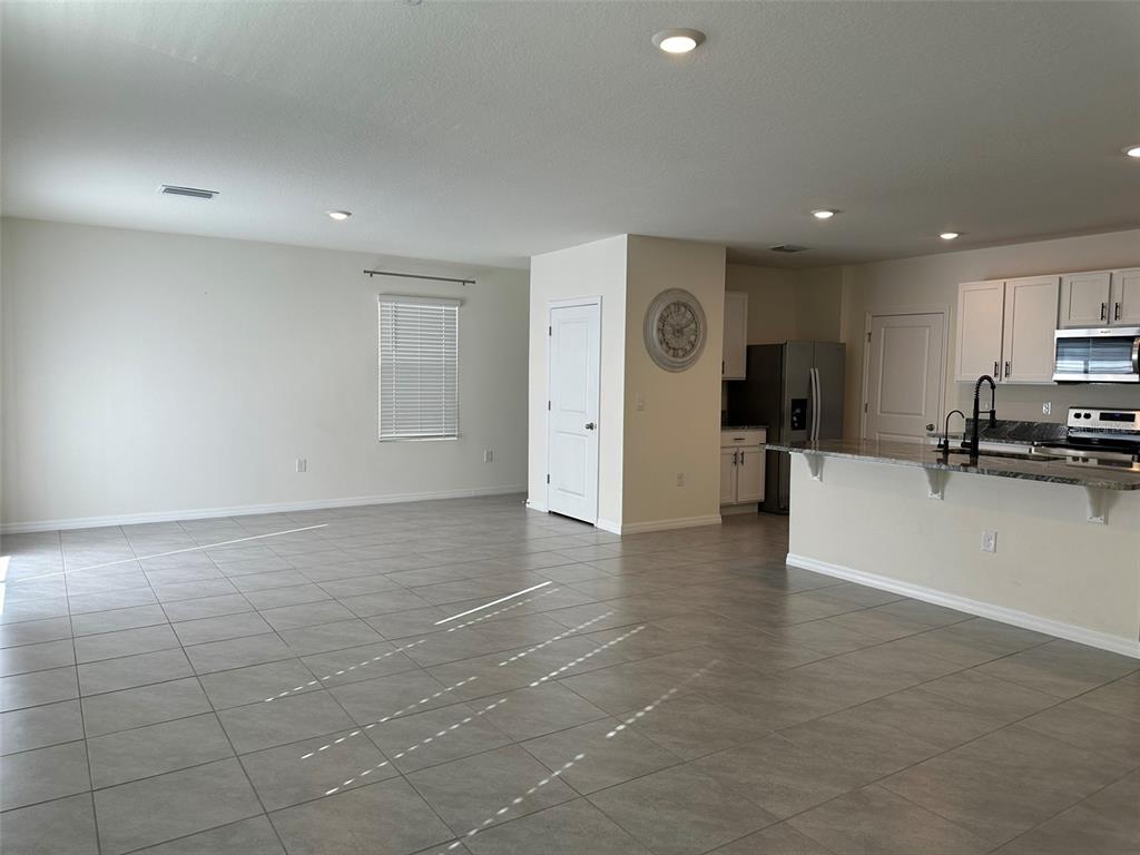 33762 Jasmine Star Loop Wesley Chapel, FL 33543 - Photo 7 of 27 a view of a livingroom with furniture and a refrigerator