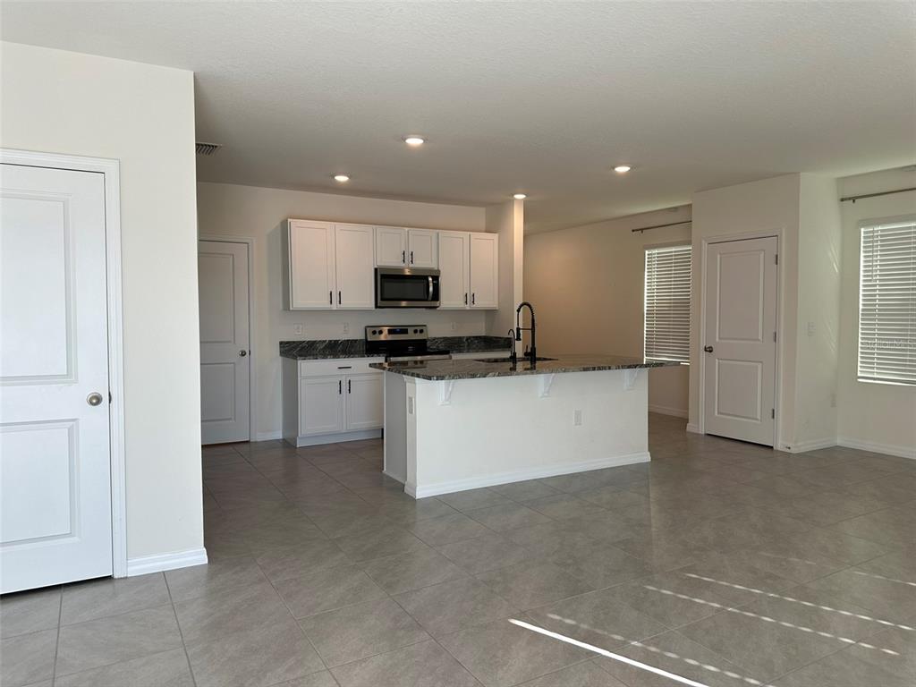 33762 Jasmine Star Loop Wesley Chapel, FL 33543 - Photo 8 of 27 a large kitchen with cabinets and stainless steel appliances