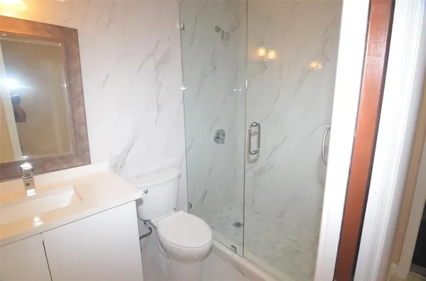 a bathroom with a sink a toilet and shower