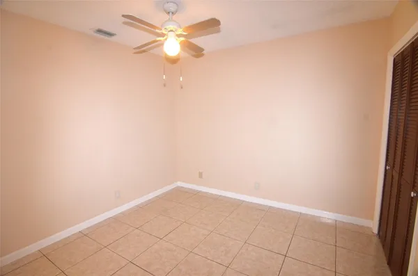 an empty room with a ceiling fan and a window