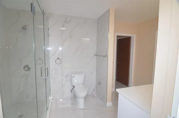 a bathroom with a toilet and a shower