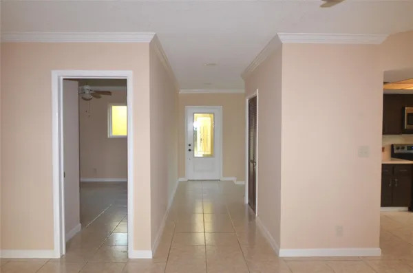 a view of a hallway with wooden floor and a living room