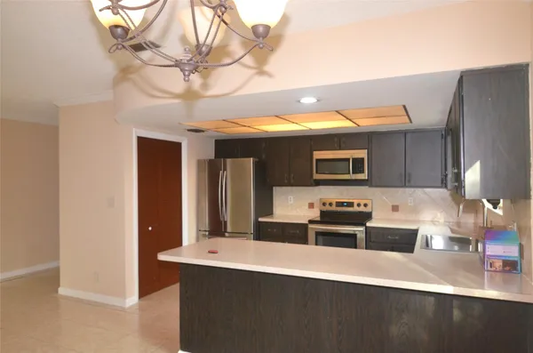 a kitchen with stainless steel appliances a sink a stove and a refrigerator